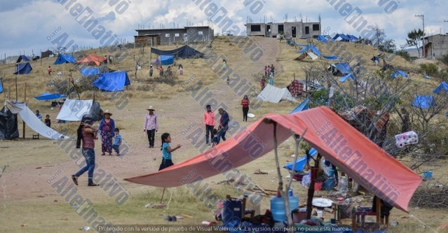 TLAPA, GUERRERO, 04ENERO2019.- Alrededor de 152 familias del municipio de Cochoapa el Grande que se dedicaban a la siembra de amapola se desplazaron de sus comunidades debido a que las ventas de la planta, que es su principal sustento, bajaron. El grupo se asentó en un terreno baldío de la ciudad de Tlapa, para exigir que gobierno estatal y federal brinde atención rápida a las familias indígenas. Las familias de La Montaña de Guerrero se mantienen de la siembra de amapola y de los envíos de dinero por parte de familiares empleados en los campos agrícolas del norte del país. Ante la baja en la venta y cotización de la planta, se vieron obligadas a migrar para huir de la pobreza extrema. Algunas familias han denunciado que sus ingresos son de 2 mil pesos anuales en promedio. Los desplazados son originarios de Tierra Blanquita, San Lucas, San Cristobalito, Llano de la Piedra, San Miguel el Nuevo, San Rafael, Llano del Metate y Rancho San Marcos, comunidades que –de acuerdo con el Inegi– tienen los indicadores de pobreza más altos de México, 56% de su población es analfabeta; 74% no es derechohabiente de algún sistema de salud, y 80% no cuenta en escusado o drenaje.Más de 500 personas, entre adultos y niños, permanecen en el campamento en la colonia Las Mesas. Ahí, con palos, cobijas y lonas, construyeron pequeños refugios para resguardarse de la lluvia, el calor y el frío. Las familias aseguran que prefieren morir en la ciudad de Tlapa que regresar a sus pueblos con mucho más dolor y soledad, asegurando que en sus lugares de origen no existe futuro para nadie.
FOTO: YAOTL SILVA /CUARTOSCURO.COM